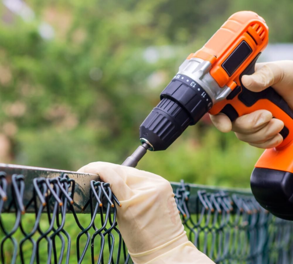Fastening,The,Metal,Mesh,Of,The,Chain-link,With,A,Drill-screwdriver
